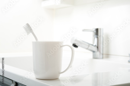 洗面台に置かれた歯ブラシとコップ