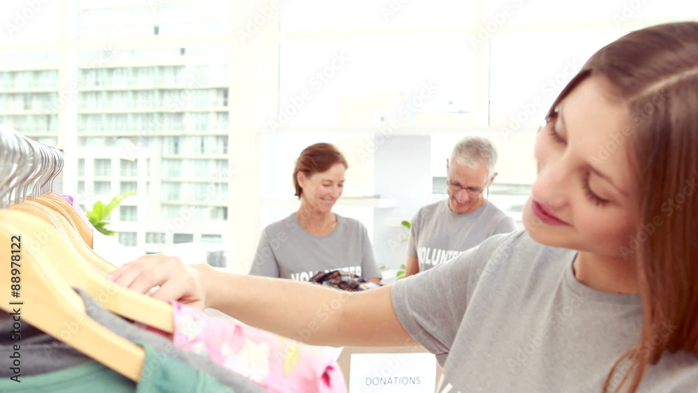 Smiling young female volunteer separating clothes Smiling young female volunteer separating clothes