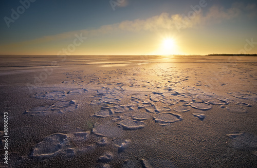 Winter landscape with lake and sunset fiery sky. 