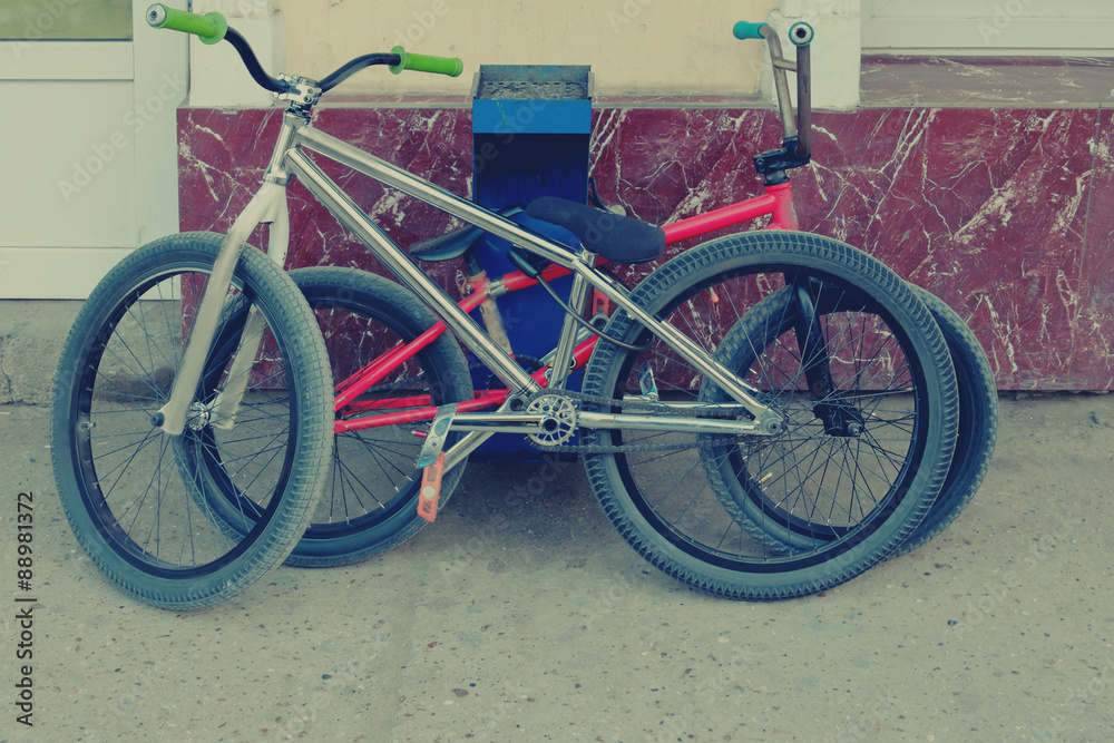 Two trendy bmx bikes near wall