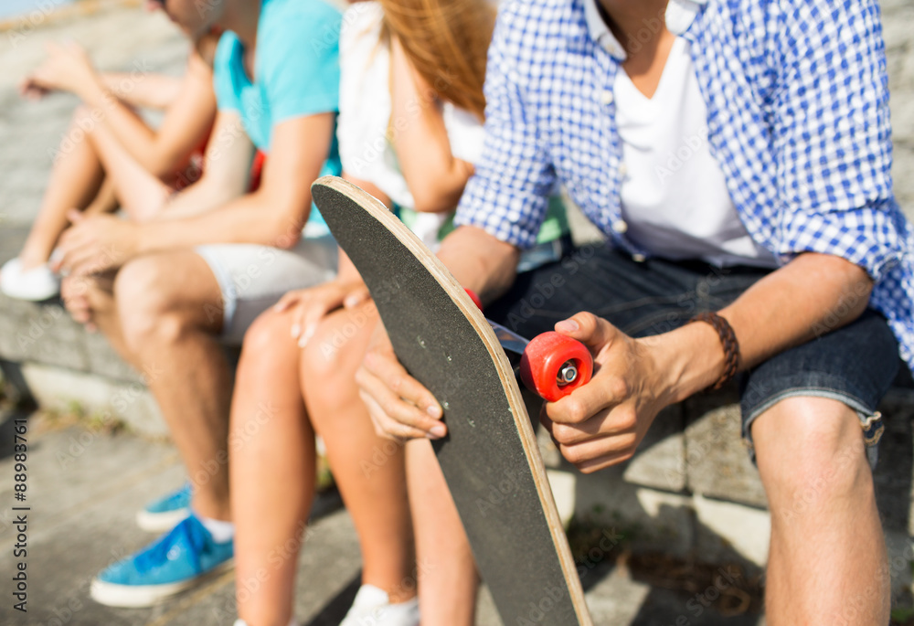 close up of friends with longboard on street