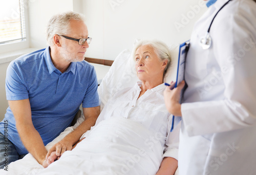 senior woman and doctor with clipboard at hospital