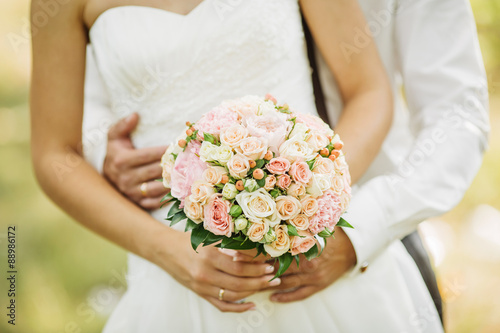 A close up of a bride holding a bouquet