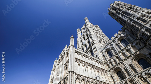 Ely Cathedral, Cambridgeshire, UK. A low, wide angle view of the historic cathedral in the Fenland city of Ely with a bright blue cloudless copy space sky. photo