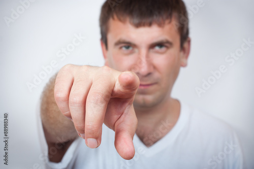 Portrait of a handsome young man pointing finger at you