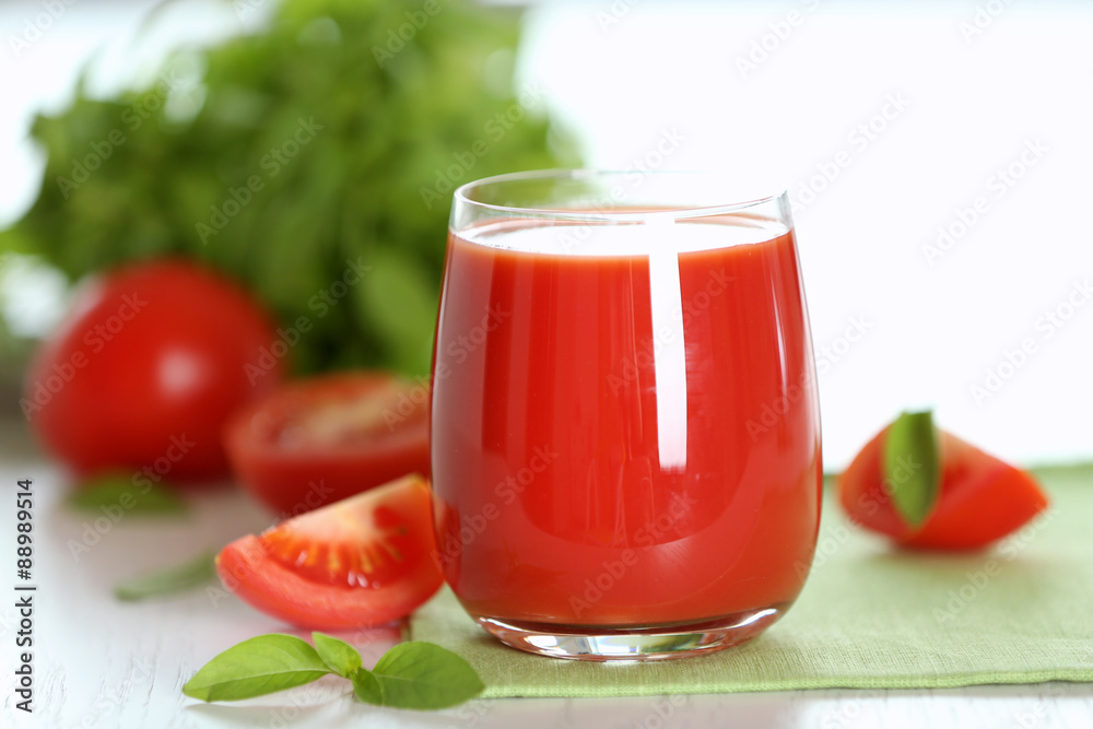 Tomato juice and fresh tomatoes on wooden table close-up Tomato juice and fresh tomatoes on wooden table close-up