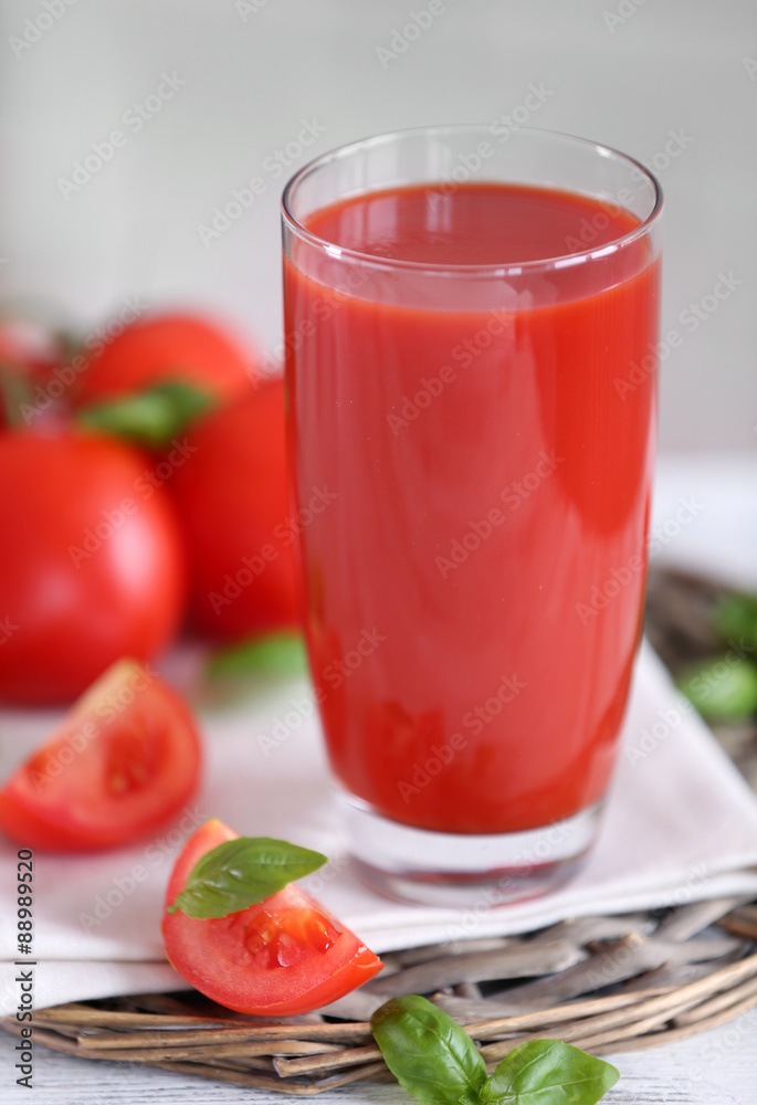 Tomato juice and fresh tomatoes on wooden table close-up Tomato juice and fresh tomatoes on wooden table close-up