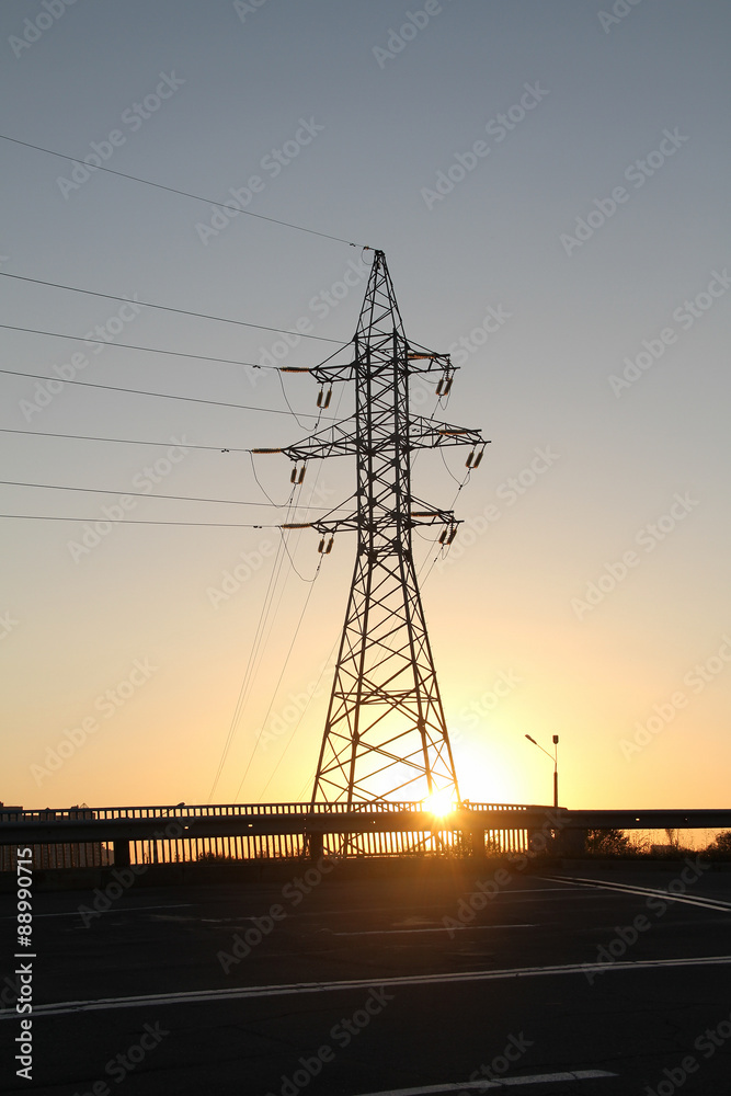 High voltage power line pylon over cloudy sky 