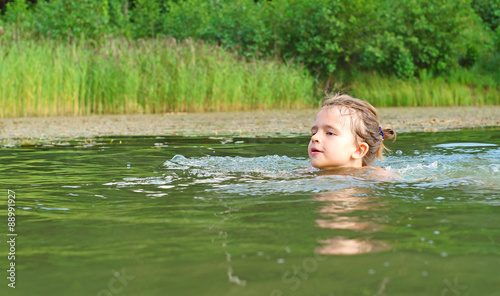 Fototapeta Naklejka Na Ścianę i Meble -  Ten year-old girl swimming in pond