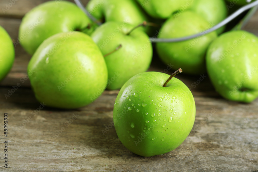 Ripe green apple in metal bucket on wooden table close up Ripe green apple in metal bucket on wooden table close up