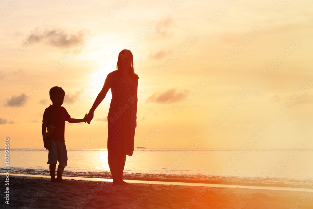 mother and son walking on sunset beach