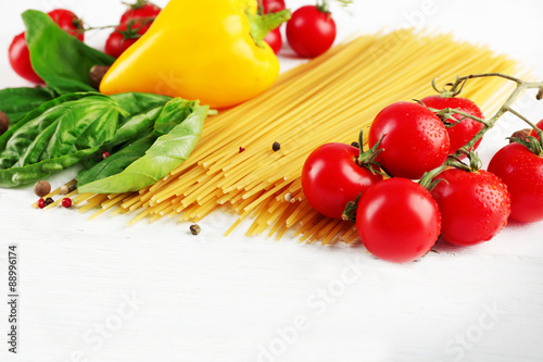 Pasta spaghetti with tomatoes, cheese and basil on color wooden background