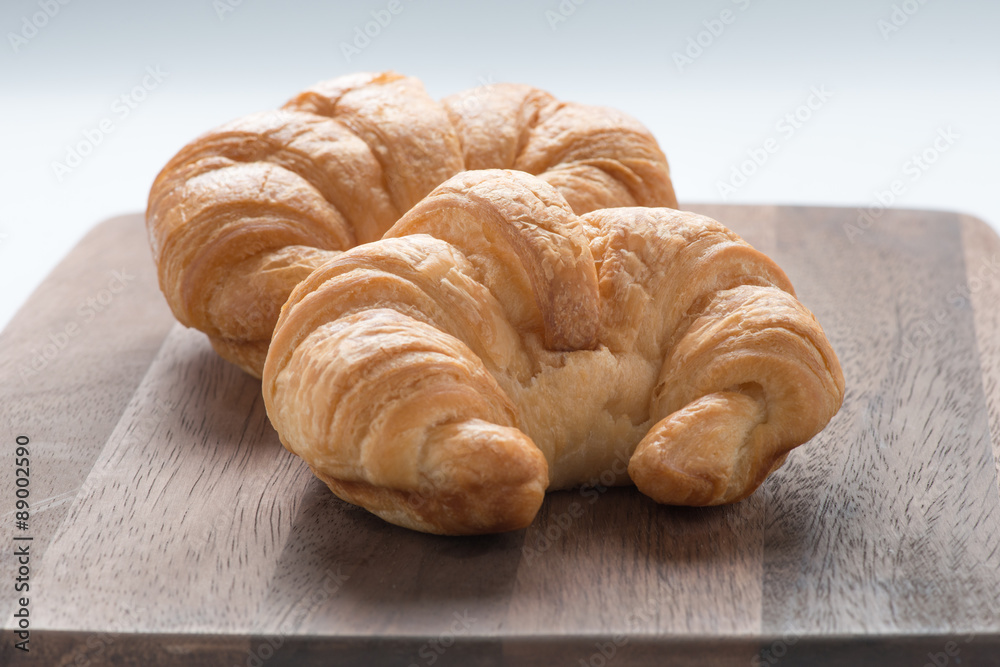 Croissant on wooden cutting board