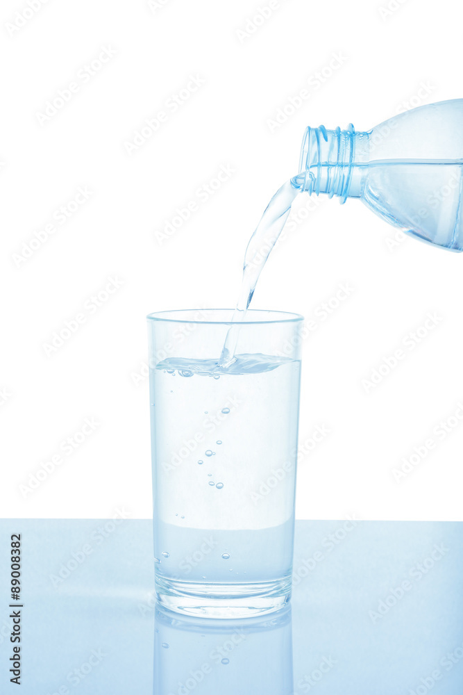 Pouring water from bottle into glass isolated on white backgroun Pouring water from bottle into glass isolated on white backgroun