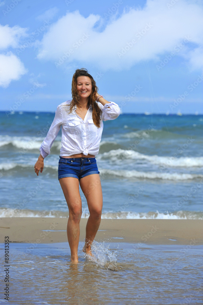 young beautiful girl walking on water at sea shore smiling happy young beautiful girl walking on water at sea shore smiling happy