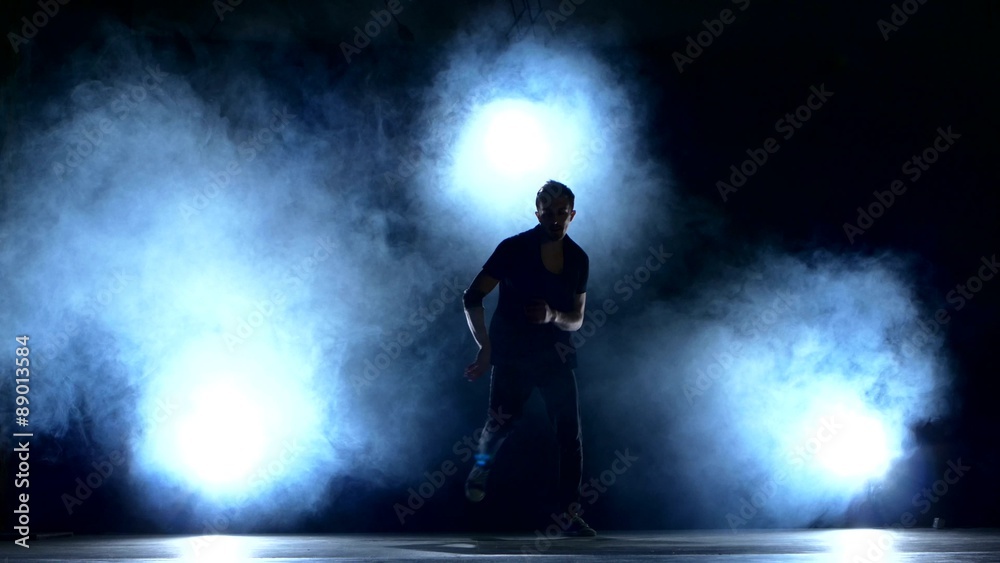 One hip hop break-dancer stylish man dancing, smoke, silhouette One hip hop break-dancer stylish man dancing, smoke, silhouette