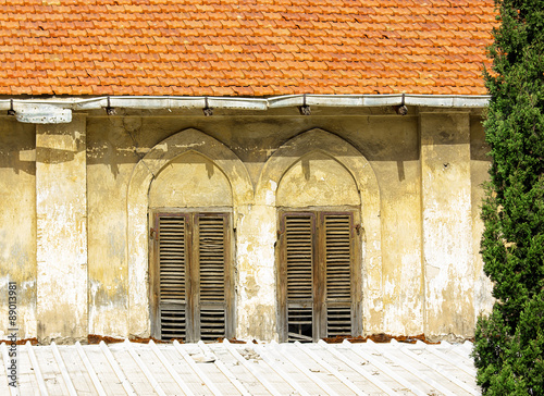 The old windows with wooden shutters on a yellow wall. Vintage background -texture.