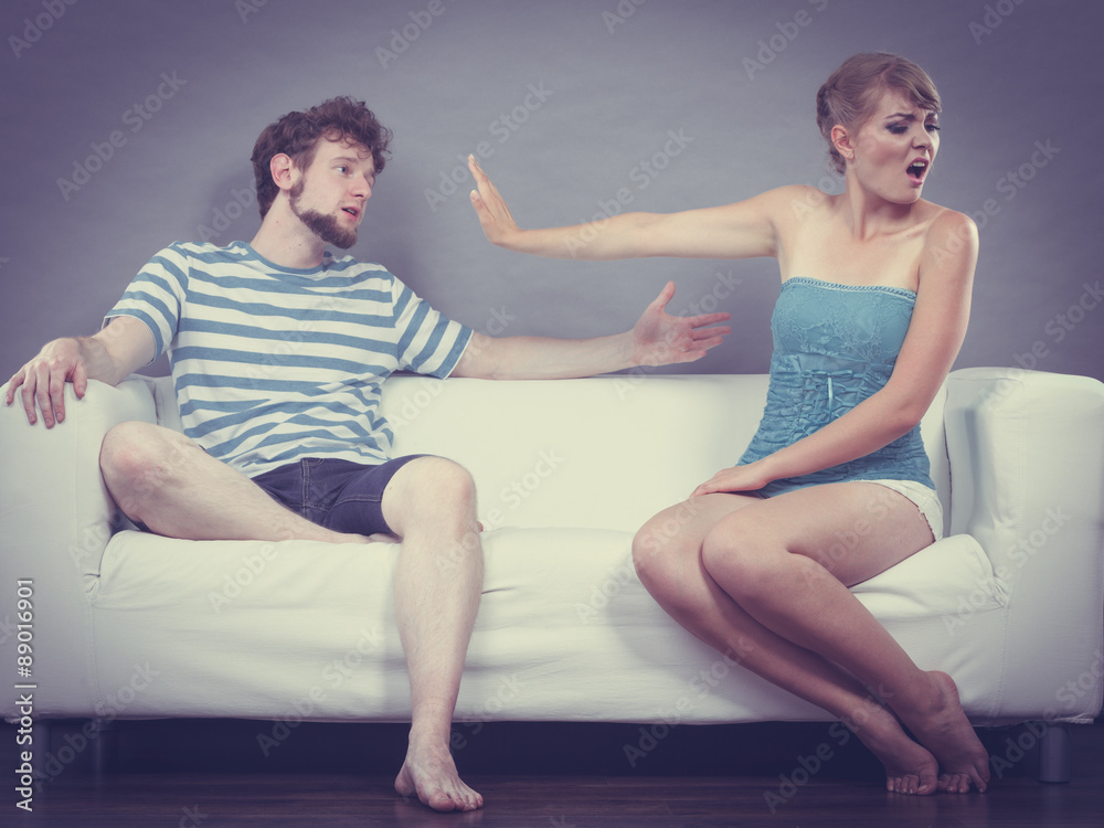 Man and woman in disagreement sitting on sofa
