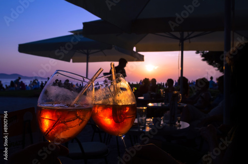 Fototapeta Naklejka Na Ścianę i Meble -  Summer evening orange cocktail in a bar by the sea at the sunset
