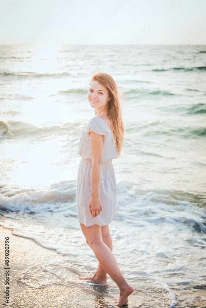 young beautiful caucasian female enjoying the sun on beach during sunrise or sunset young beautiful caucasian female enjoying the sun on beach during sunrise or sunset