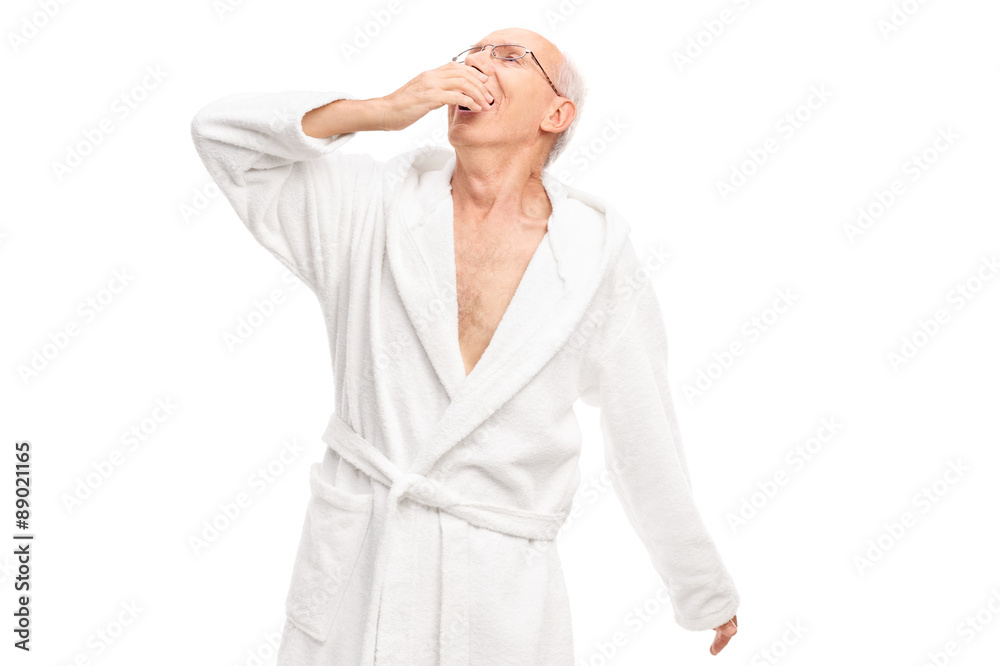 Sleepy senior man in a white bathrobe yawning Sleepy senior man in a white bathrobe yawning