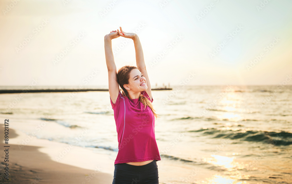 Fitness sport model smiling happy doing exercises during outdoor work out on sunrise. Beautiful caucasian female training outside on seaside in the morning Fitness sport model smiling happy doing exercises during outdoor work out on sunrise. Beautiful caucasian female training outside on seaside in the morning