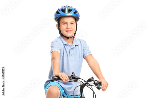 Little boy with blue helmet sitting on his bicycle and looking a