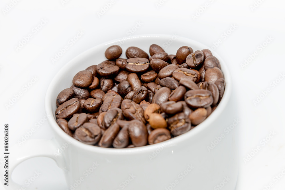 Coffee beans seed in white cup isolated highkey Coffee beans seed in white cup isolated highkey