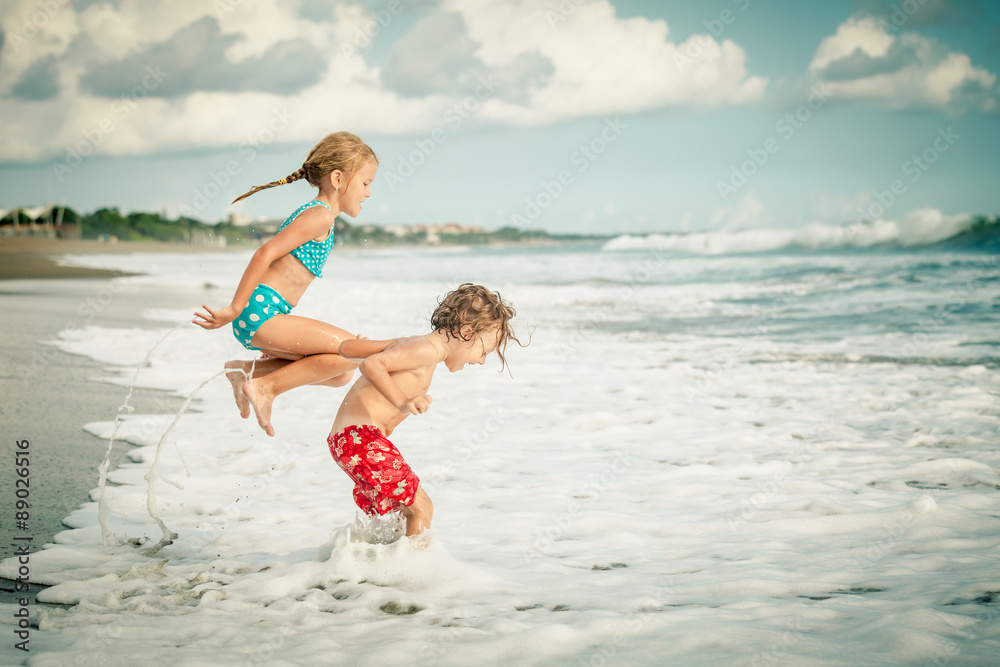 Naklejka premium Two happy children playing on the beach