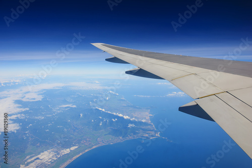 Airplane flying over ocean and island