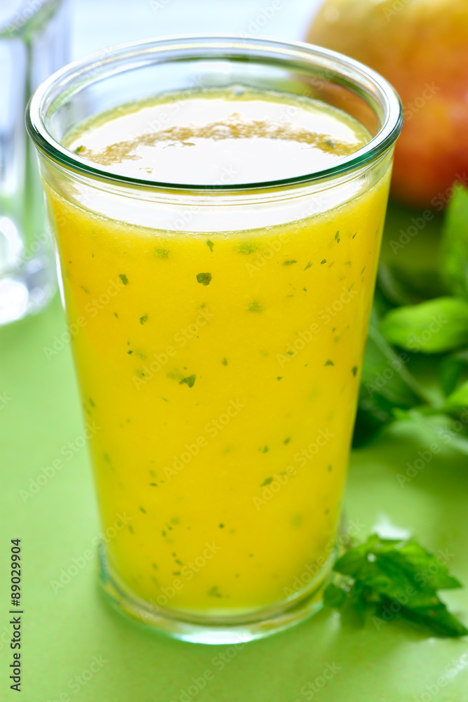 Cooling Mango mint smoothie, summer drink on green table, Yellow Tropical Smoothie made with mango, mint and lime juice. Cooling Mango mint smoothie, summer drink on green table, Yellow Tropical Smoothie made with mango, mint and lime juice.