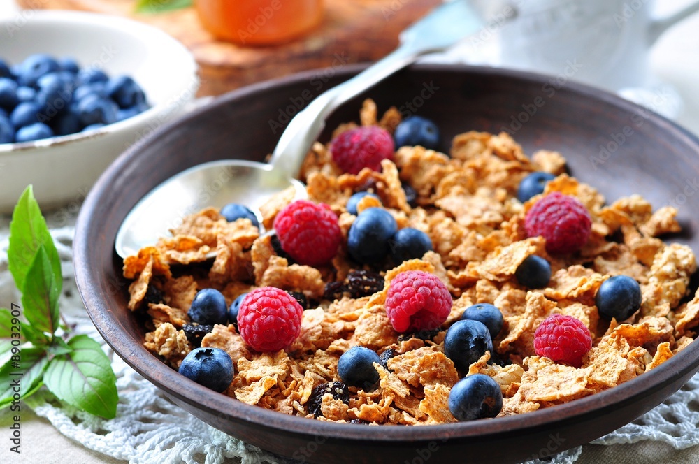 homemade granola with fresh blueberries, raspberries, raisins, milk and honey. Healthy Breakfast