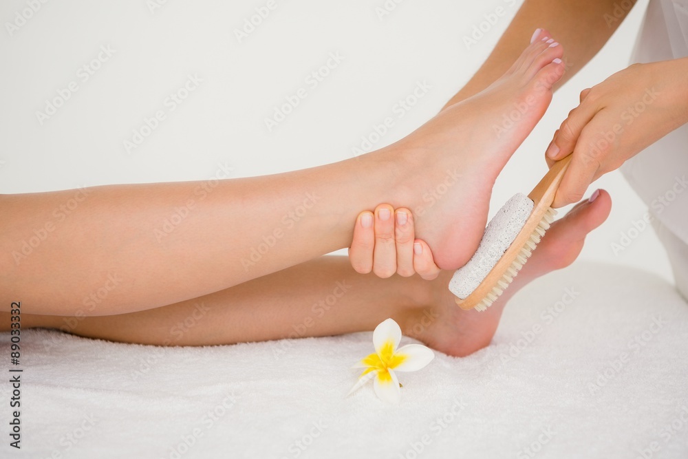 Naklejka premium Side view of a young woman receiving pedicure treatment