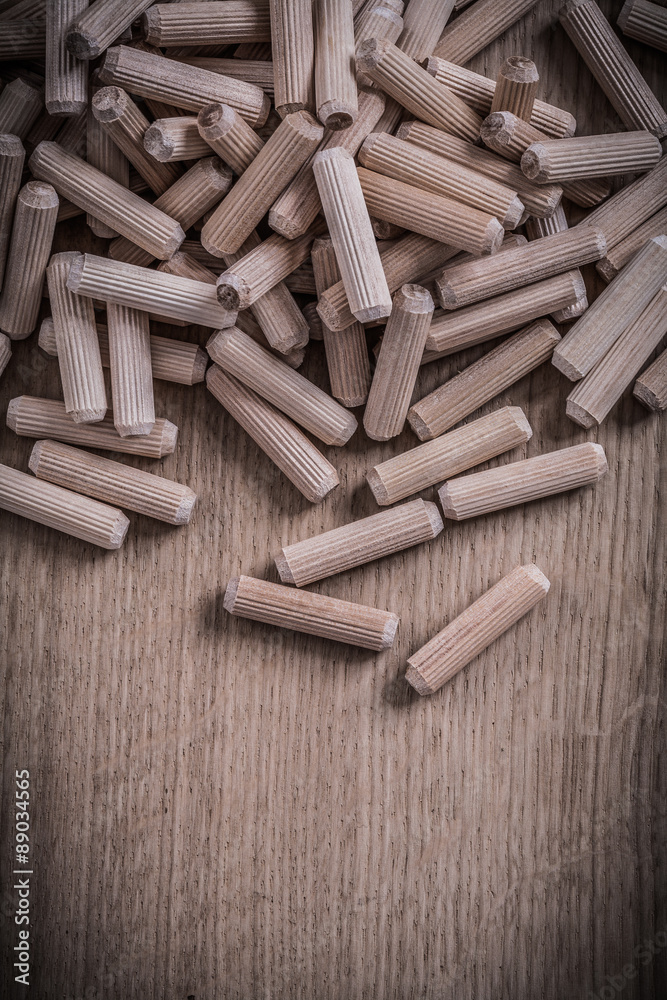 Variety of cylinder wooden dowel pins on wood board construction Variety of cylinder wooden dowel pins on wood board construction