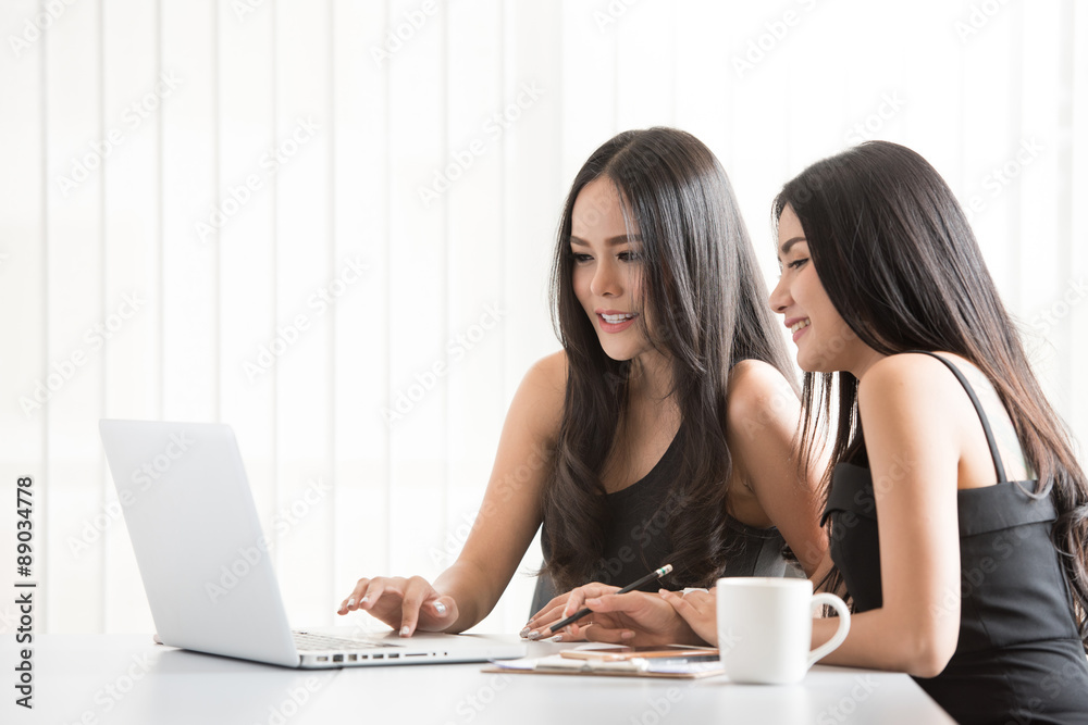 Two asian business women having a meeting with laptop in modern Two asian business women having a meeting with laptop in modern