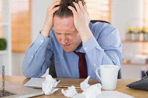 Stressed businessman with head in hands
