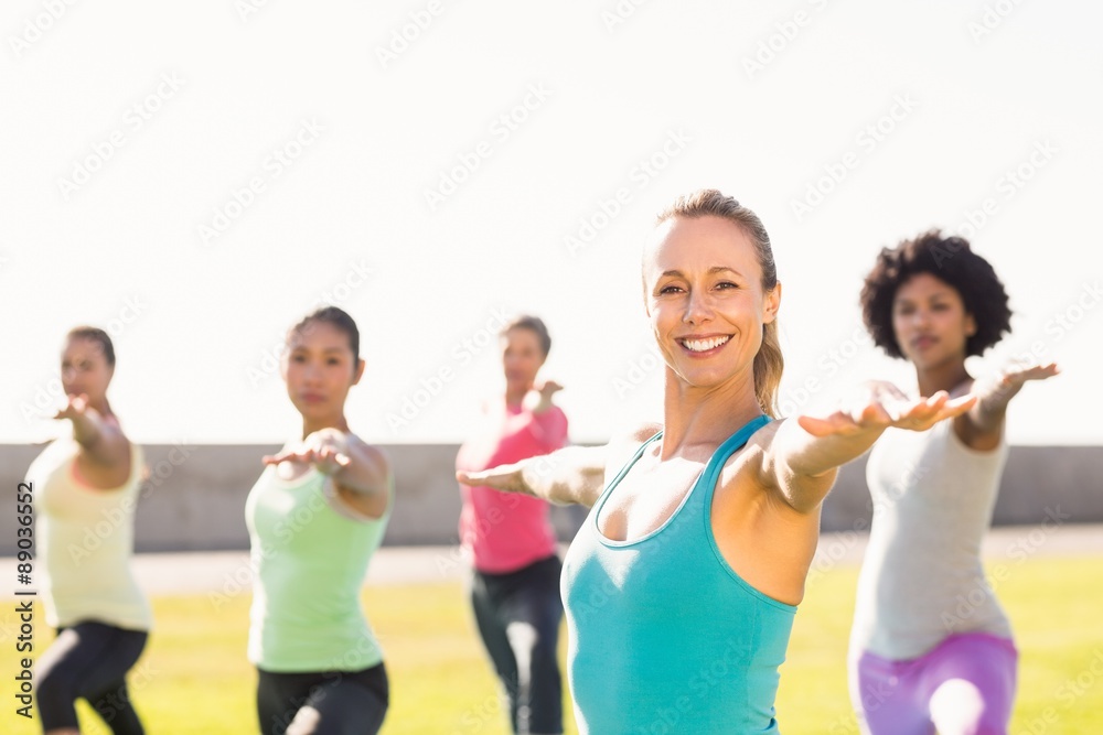 Smiling sporty blonde doing yoga in yoga class