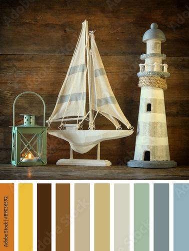 old vintage wooden white sailing boat on wooden table with palette color swatches © tomertu