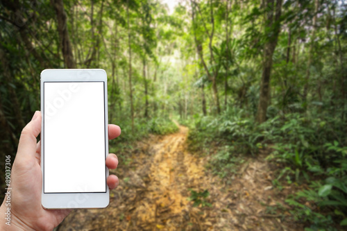 Business conceptual- Focused on left hand holding mobile with Trekking nature blurred background