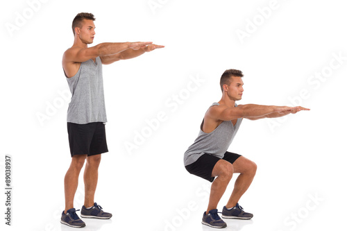 How To Make a Squat. Muscular man showing a squat exercise, side view, step by step.  Full length studio shot isolated on white. photo