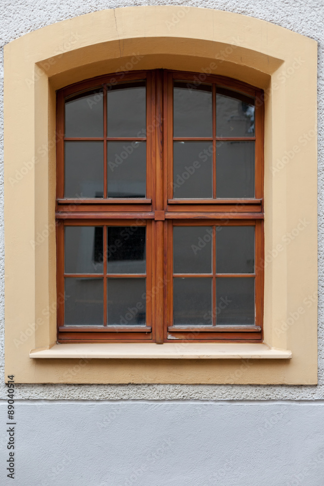 Large wooden, arched window in the building.