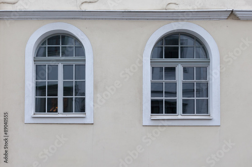 Two large, white arched windows in the building.