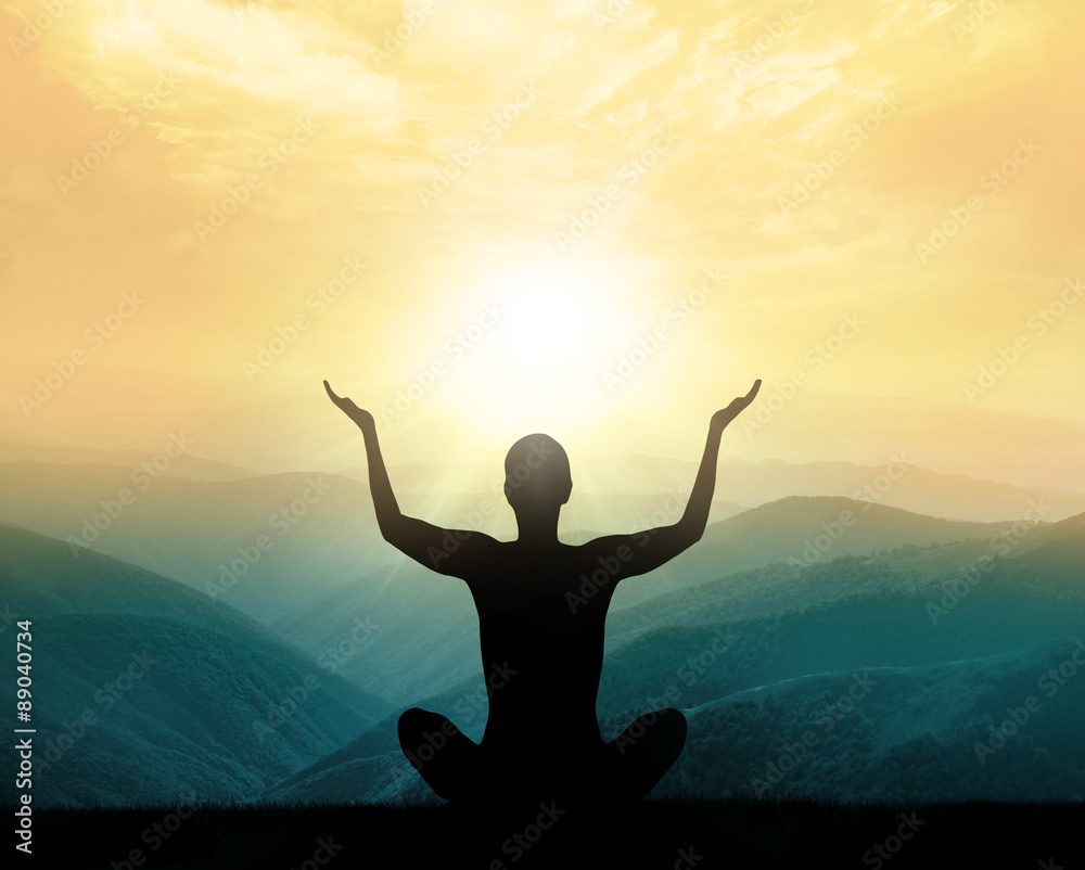 Yoga and meditation. Silhouette of man in mountains.