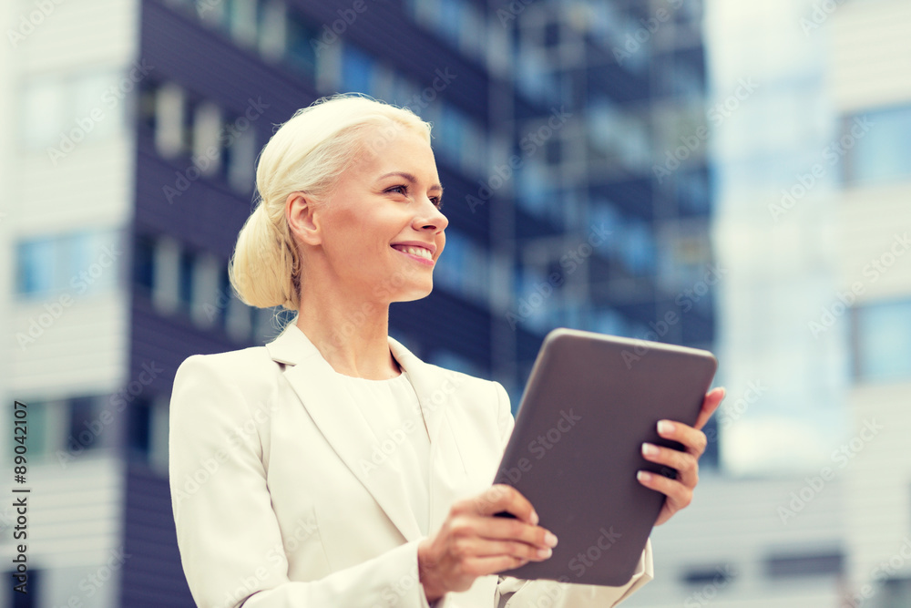 smiling businesswoman with tablet pc outdoors