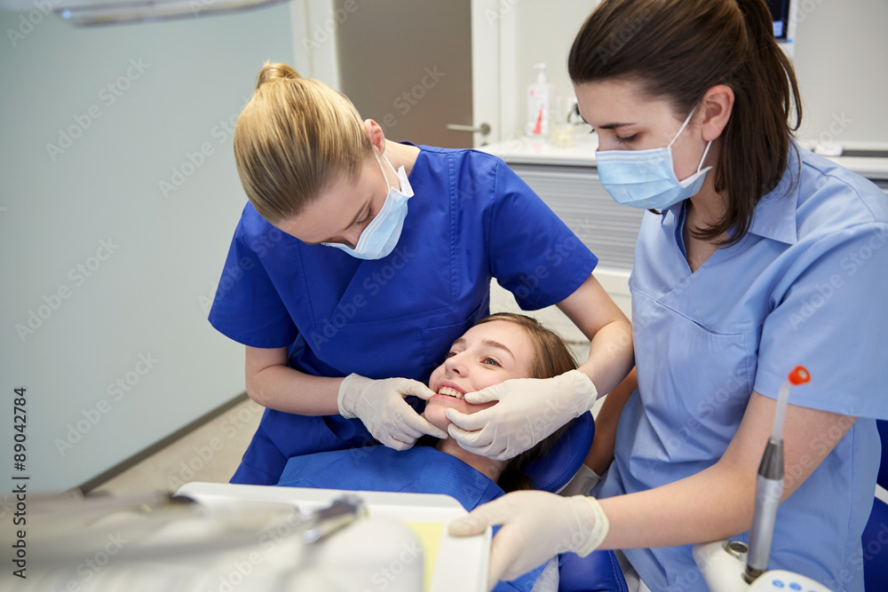 happy female dentist with patient girl at clinic happy female dentist with patient girl at clinic