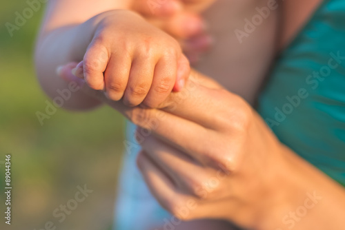Family, love and care concept. Hands of mother and baby closeup