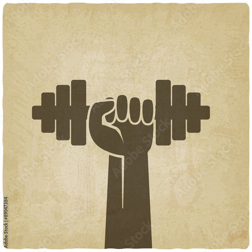 hand with dumbbell. fitness symbol on old background