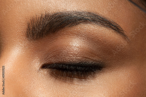 Canvas-taulu Close-up closed eye with make-up with brown eyebrows and black lashes