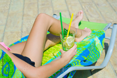 Woman relaxing in hammock-chair with a glass of refreshing lemonade