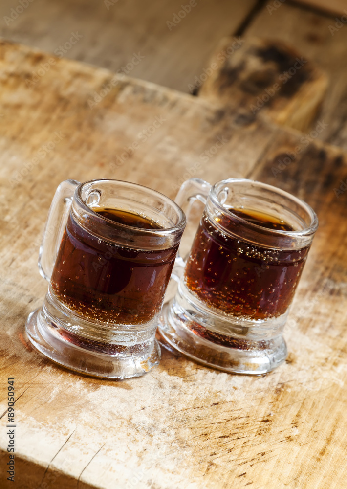Dark beer in an old-fashioned cups, selective focus Dark beer in an old-fashioned cups, selective focus